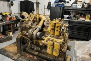 Diesel Engine with multiple cylinders on a wooden platform in a autoshop.