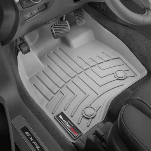 Gray WeatherTech floor mat placed on the drivers side of a vehicle, covering the floor and pedals.